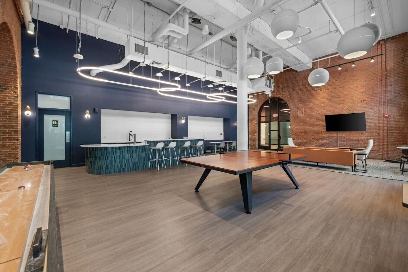 A modern interior with a long table, bar area, and seating.