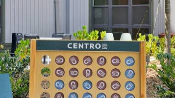 A wooden board game with the word 'CENTRO' at the top, surrounded by greenery.