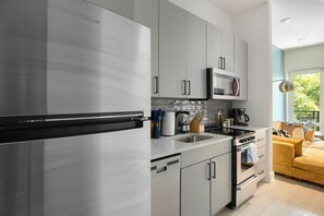 A modern kitchen with stainless steel appliances, a microwave, and a sink.