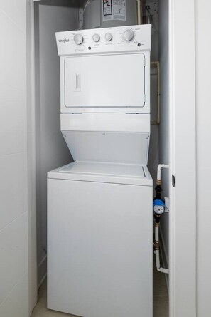 A compact, white, wall-mounted washer and dryer unit with a control panel and a water inlet. - 1BR King w/ Gym + Courtyard w/ Grill Station + Free Parking, NoDa Art District (Charlotte)