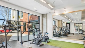 Uma academia com bicicletas ergométricas, esteiras e aparelhos de musculação.