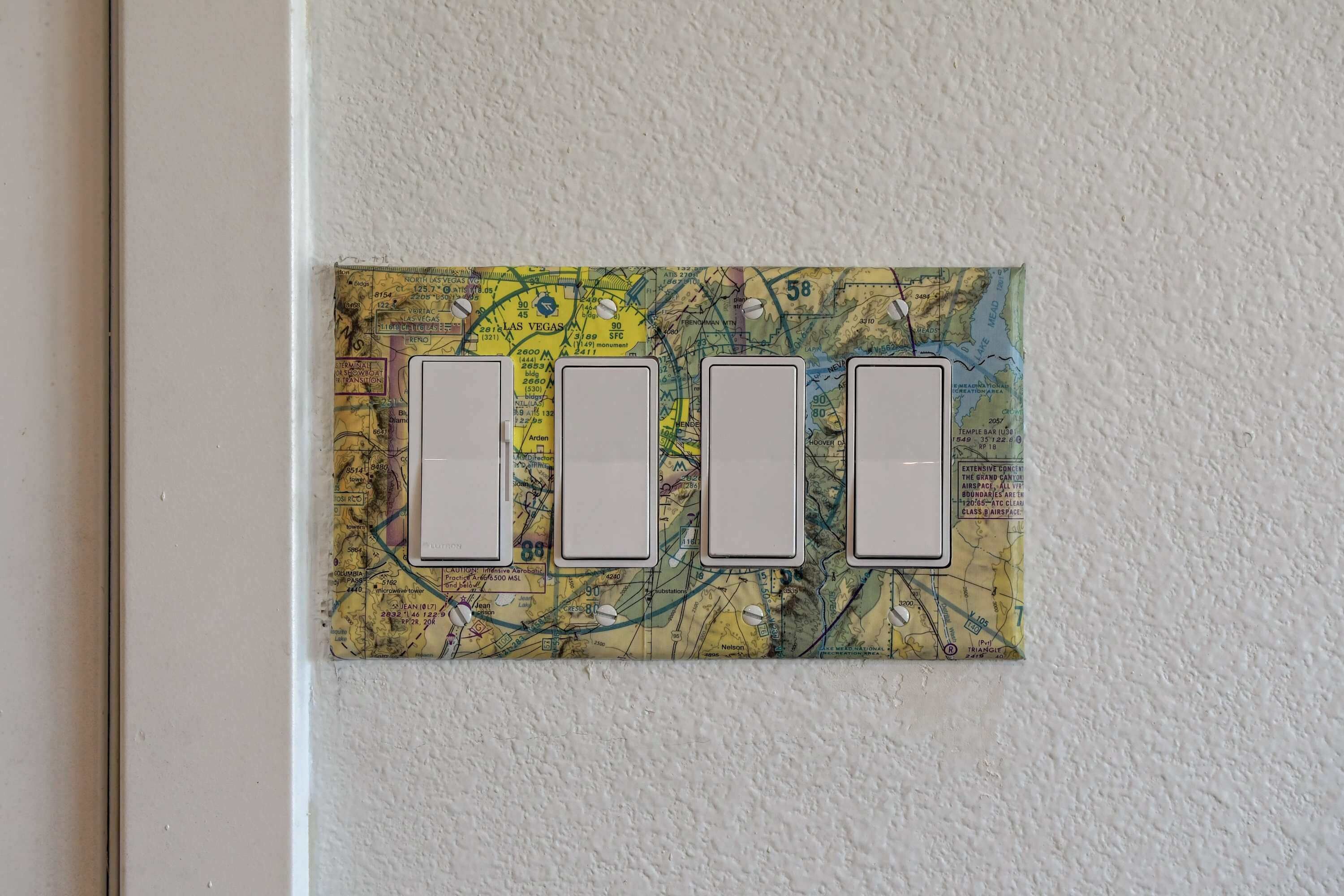 A wall-mounted switchboard with three blank switches.