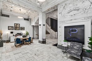 A hotel lobby with a marble floor, a reception desk, a staircase, and a framed sign with the letter 'P'. - King Studio / Pool Table + Gym + Free Coffee Bar / 0.3 miles to Fountain Square (Cincinnati)