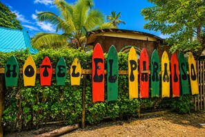 A wooden fence with colorful surfboard-shaped signs spelling out 'HOTEL EL PARADISO'. - Hotel Cabañas el Paraiso en Sapzurro (Sapzurro)