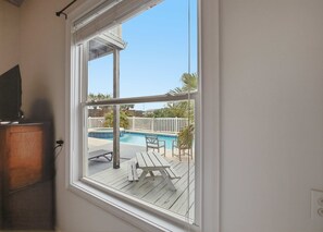 A window with a view of a swimming pool and patio furniture. - NEW- Salt Therapy - 5 BDR- Pool- St. George Island (Saint George Island)