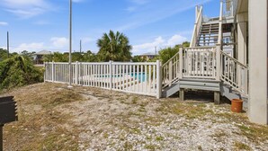 A residential property with a swimming pool, a white fence, and a staircase leading to a balcony. - NEW- Salt Therapy - 5 BDR- Pool- St. George Island (Saint George Island)