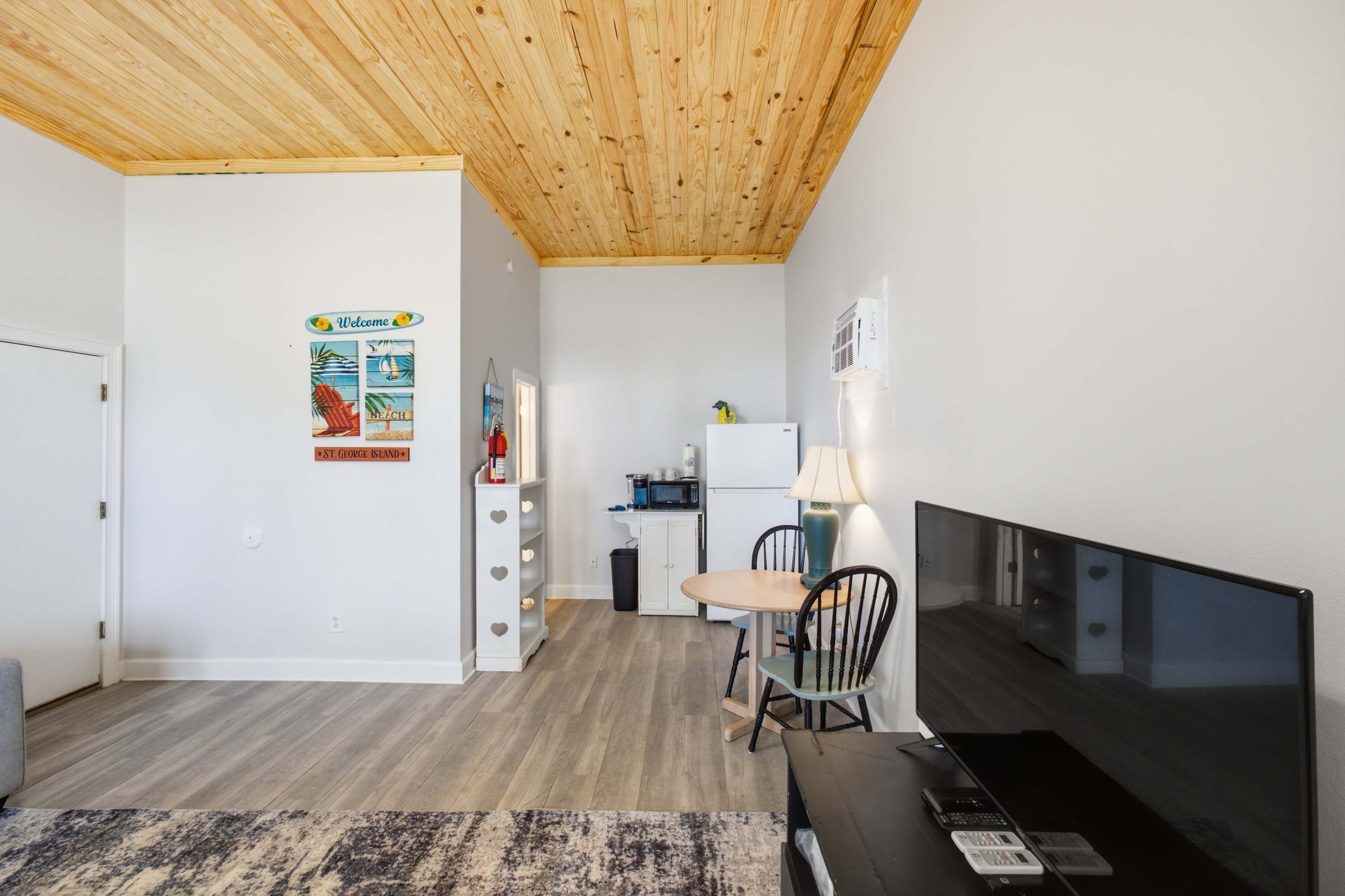 A compact living space with a kitchenette, a dining area, and a television.