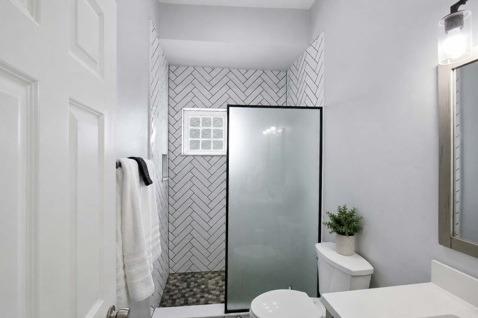 A bathroom with a shower, toilet, and sink.
