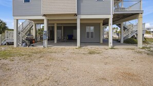 A two-story building with a covered outdoor area and a staircase leading to a balcony. - NEW- Salt Therapy - 5 BDR- Pool- St. George Island (Saint George Island)
