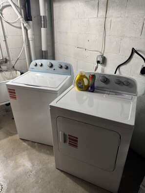Two front-loading washing machines with a detergent bottle and a bottle of fabric softener on top. - 3-bedroom house in welcoming Pittsburgh with cool AC breeze (Pittsburgh)