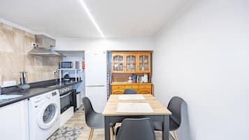 Cocina compacta con lavadora, microondas y estufa.