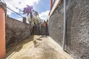 A narrow alleyway with a concrete staircase leading to a higher level. - A Quintinha by Your Key Madeira (Santa Cruz)