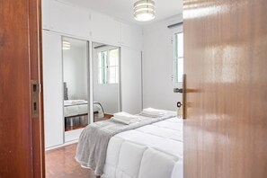 Ein Schlafzimmer mit Bett, Spiegel und Kleiderschrank.