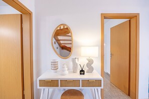 A white console table with a mirror, a lamp, and decorative items. - Cozy Haven Santana by YOUR KEY (Santana)