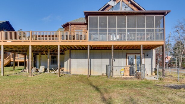 A two-story house with a balcony, a covered porch, and a fenced yard. - Wonderful 6-bedroom house with Hot Tub in charming Luray (Luray)