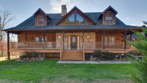 A log cabin with a stone facade, a front porch with railings, and a steeply pitched roof. - Wonderful 6-bedroom house with Hot Tub in charming Luray (Luray)