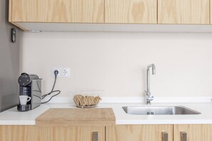 A kitchen with wooden cabinets, a coffee maker, a bowl of bread, and a sink. - Endless Horizon by YOUR KEY (Santa Cruz)
