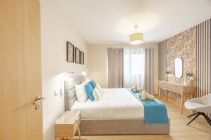 A modern bedroom with a bed, bedside table, and a chair. - Fénix Horizon Suite by YOUR KEY (Santa Cruz)