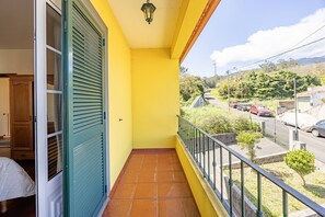 A balcony with a view of a street, a door with shutters, and a tiled floor. - L&P Countryside by YOUR KEY (Santana)