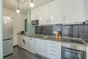 A modern kitchen with stainless steel appliances, a built-in oven, and a microwave. - Lux Mare Funchal by YOUR KEY (Funchal)