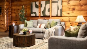 A cozy living room with a sofa, a coffee table, and a lamp. - VIEWS! / Hot Tub / Nintendo Switch / Games! (Sevierville)