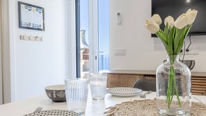 A dining table with plates, cutlery, and a vase with flowers. - Maison Des Souvenir B by YOUR KEY (Ribeira Brava)
