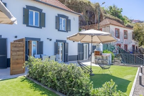 Una propiedad residencial con zona de patio, mobiliario exterior y césped bien cuidado.