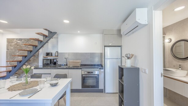 A modern kitchen with a built-in oven, microwave, and refrigerator. - Maison Des Souvenir B by YOUR KEY (Ribeira Brava)
