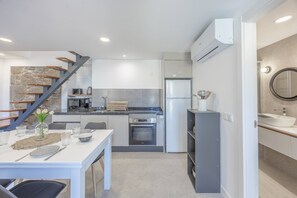 Une cuisine moderne équipée d’un four, d’un micro-ondes et d’un réfrigérateur encastrés.