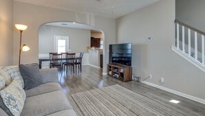 A living room with a sofa, TV, and a ceiling fan. There is a dining area with chairs and a table, and a kitchen in the background. - Near Shelbyville, TN. Perfect for long term stays (Murfreesboro)