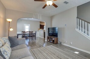 A living room with a sofa, TV, and a ceiling fan. There is a dining area with chairs and a table, and a kitchen in the background. - Near Shelbyville, TN. Perfect for long term stays (Murfreesboro)