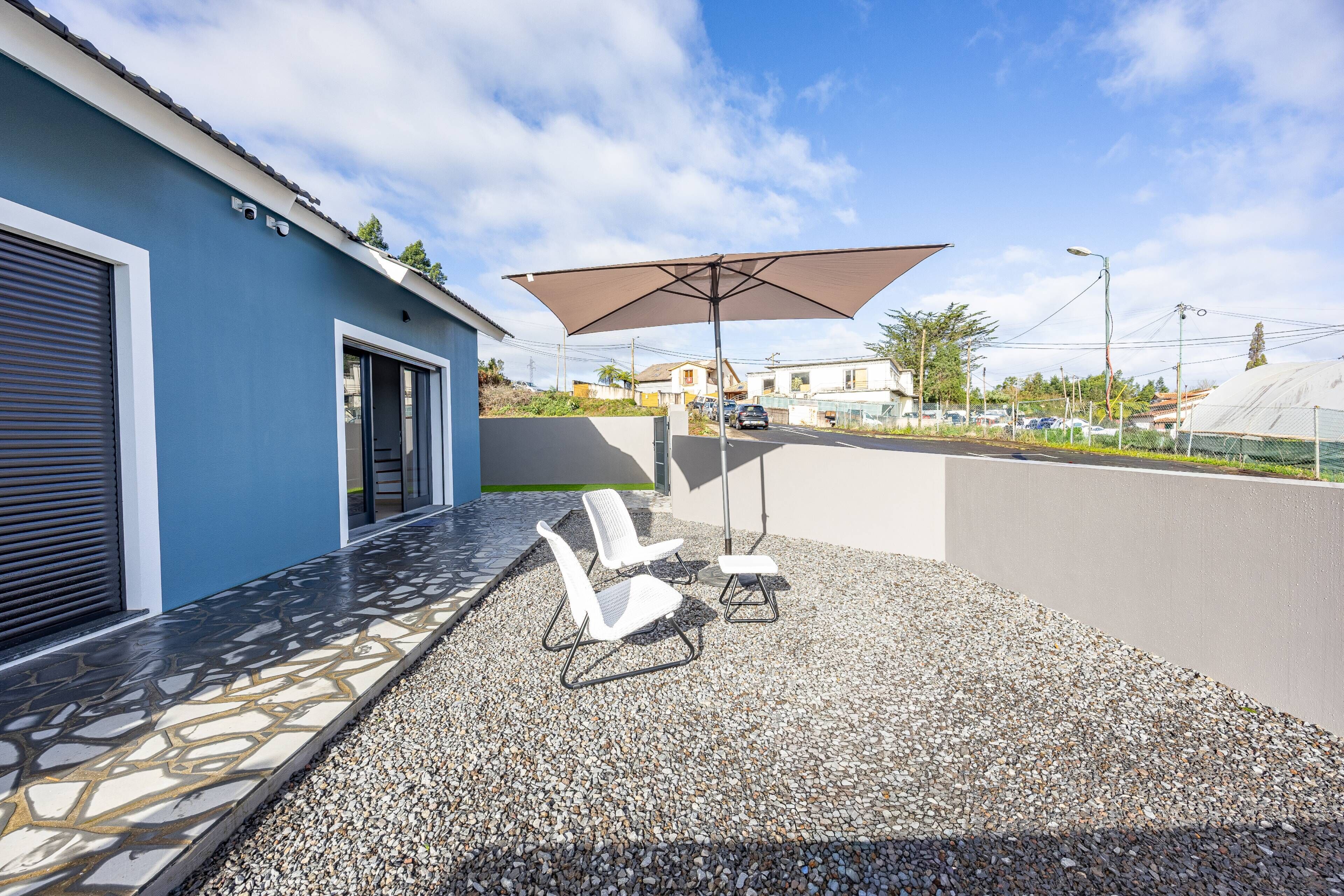 Terraço no telhado com área de estar, pérgola e vista do bairro ao redor.