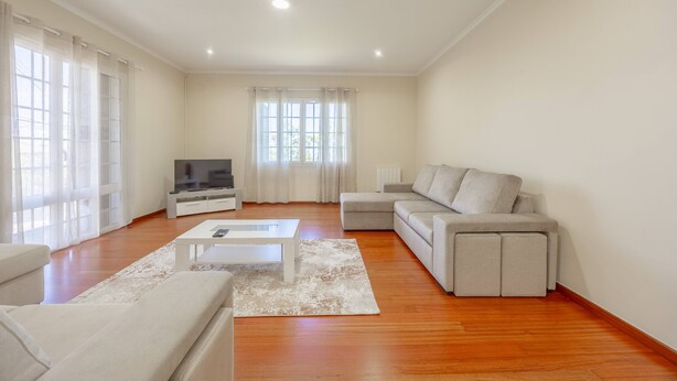 Un salón amplio con sofá, mesa de centro y televisor.