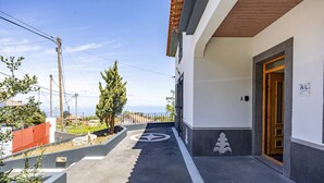 Entrada de un edificio con rampa accesible para sillas de ruedas, un buzón y una puerta identificada con la etiqueta 'AL'.