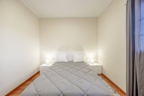 Ein Schlafzimmer mit einem Bett, zwei Nachttischen und einem Beistelltisch.