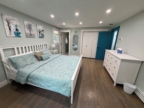 Ein Schlafzimmer mit einem Bett, einem Schminktisch und Kunstwerken an der Wand.