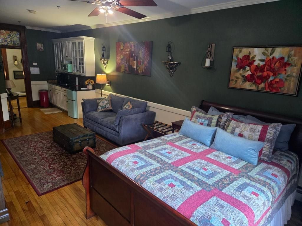 A bedroom with a bed, a sofa, a small table, and a cabinet.