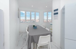 A dining area with a table, chairs, and a view of the city through large windows. - HOUZE City Center spacious 9 rooms flat, best view (Lisboa)