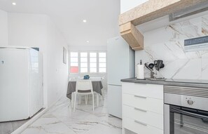 A modern kitchen with white cabinetry, a marble backsplash, and a built-in oven. - HOUZE City Center spacious 9 rooms flat, best view (Lisboa)