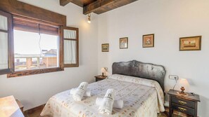 Ein Schlafzimmer mit einem Bett, Nachttischen, einem Fenster und Bildern an der Wand.