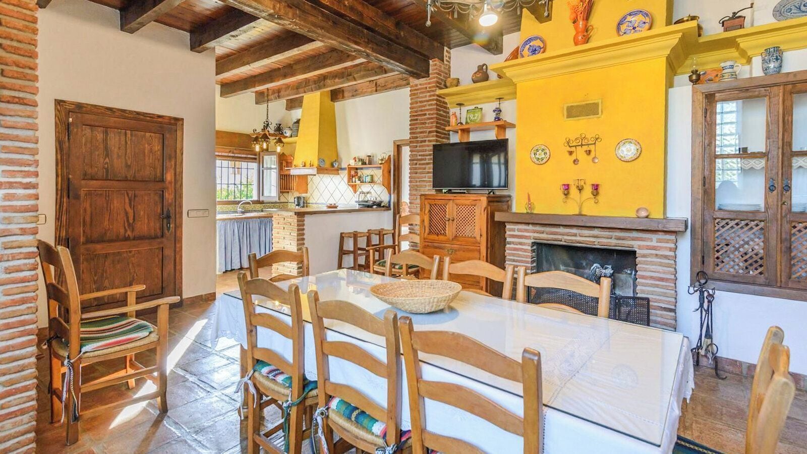 A dining area with a table set for four, surrounded by wooden chairs.
