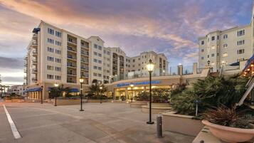 Un hotel con varios pisos, mesas al aire libre y un letrero que dice 'Wyndham Oceanside Pier'.