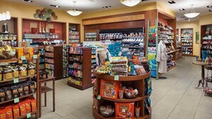 Een netjes ingerichte winkel met diverse verpakte producten, waaronder snacks en drankjes, tentoongesteld op schappen en toonbanken.