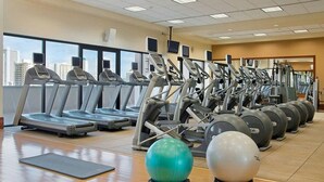 Een sportschool met loopbanden, elliptische trainers en fitnessballen.