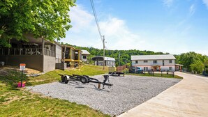 Un barrio residencial con un camino de grava, una caravana y una casa con porche.