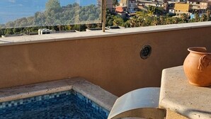 A rooftop pool with a clear view of the sea and buildings in the background. - Luxury Suite (Palmi)