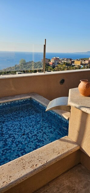 Ein Pool auf dem Dach mit freiem Blick auf das Meer und Gebäude im Hintergrund.
