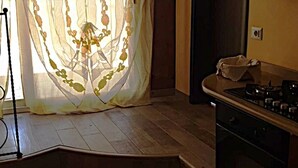 A kitchen with a gas stove, a sink, and a window with sheer curtains. - Luxury Suite (Palmi)