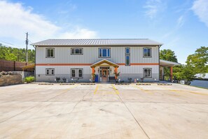 A two-story building with a flat roof, a central entrance with a porch, and a parking lot in front. - FUN TIMES LUXURY RESORT-3BD/2BA-LAKEFRONT-POOL-ARCADE-PLAYAREA-DOG AREA-MARINA (Jacksboro)