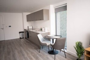 Eine moderne Küche mit Essbereich, Mülleimer und Fenster mit Blick.